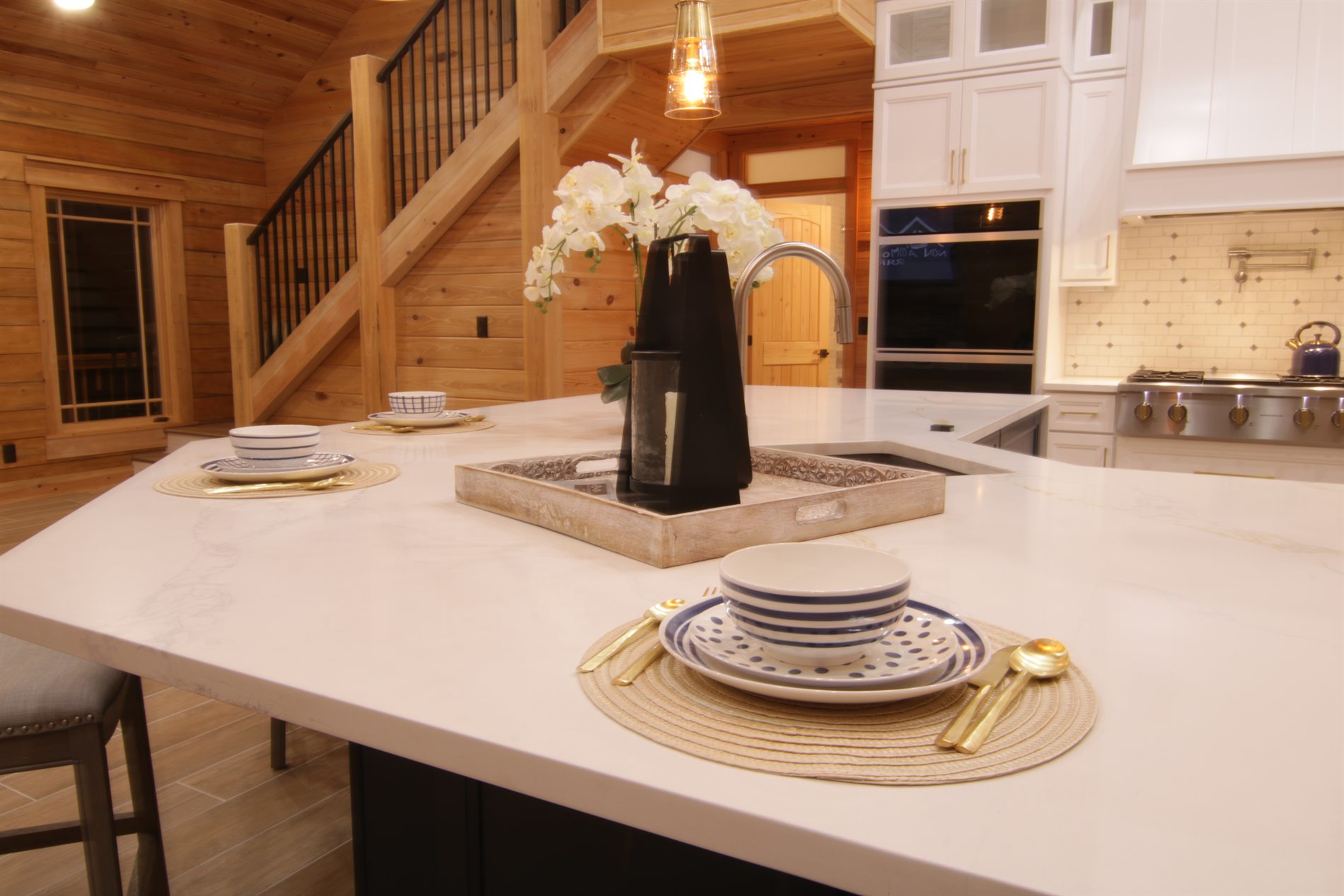 Kitchen island finish detail with wood walls and white cabinetry in an Apopka custom log cabin