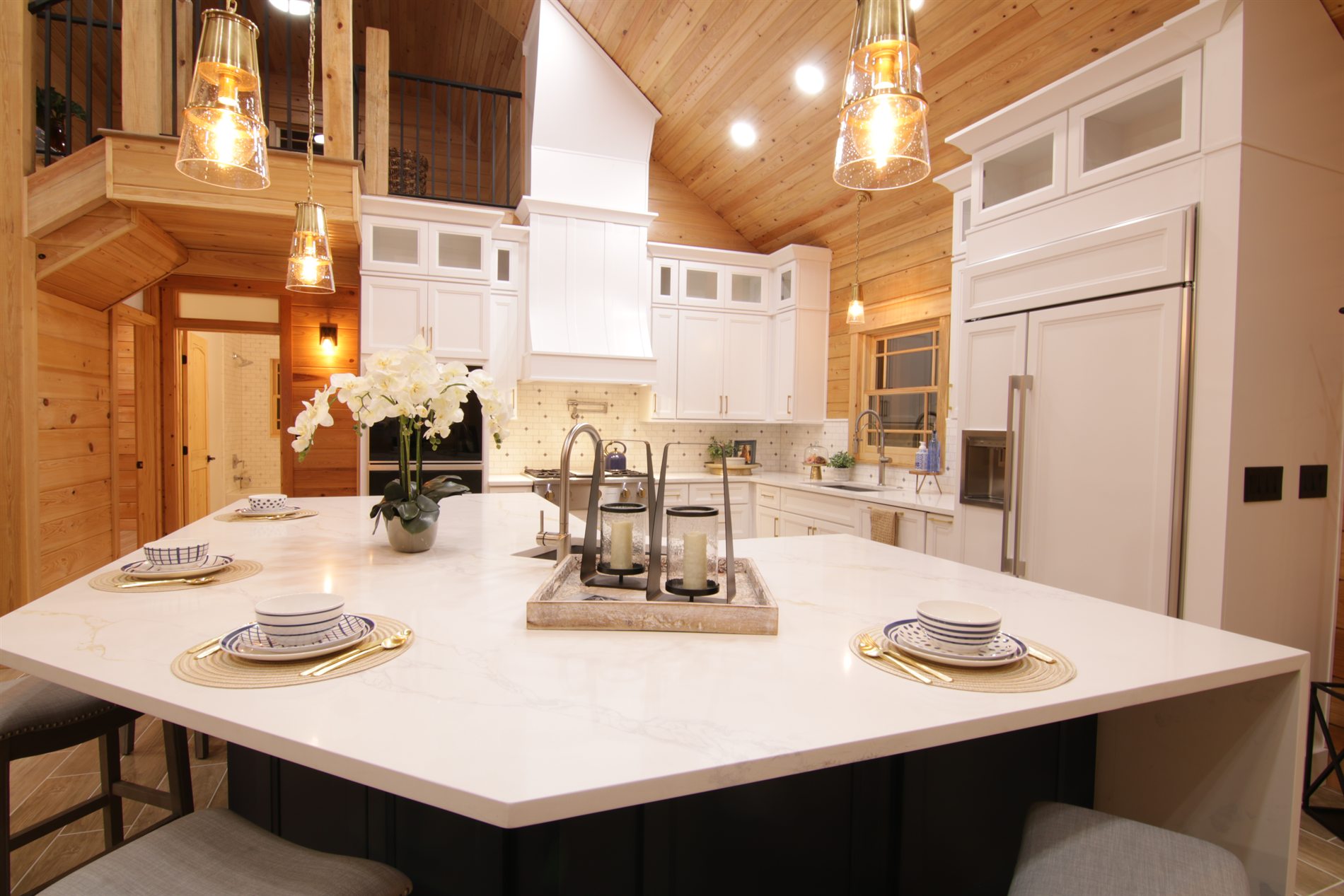 White cabinetry and large kitchen island inside an Apopka custom log cabin