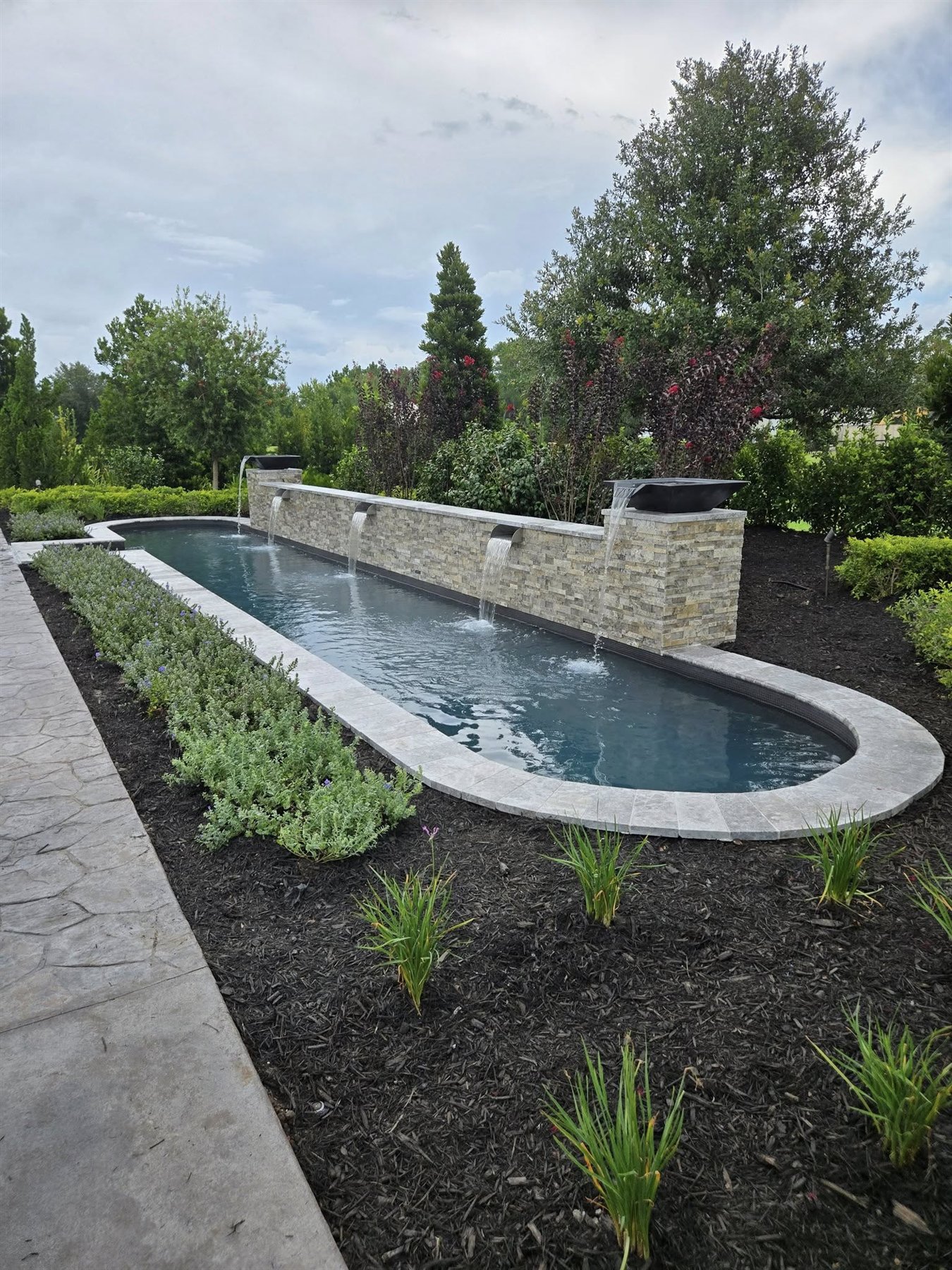 Custom Orlando pool with stone water feature and outdoor living landscaping