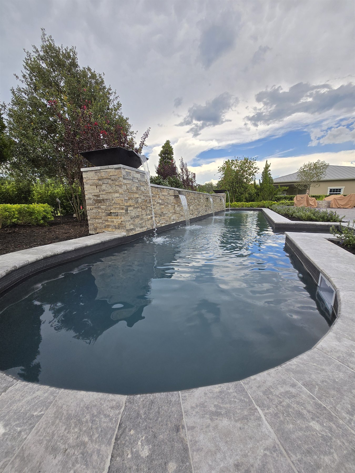 Pool water feature with stone wall and coping detail